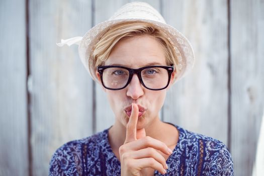 Pretty blonde woman wearing hipster glasses on wooden background