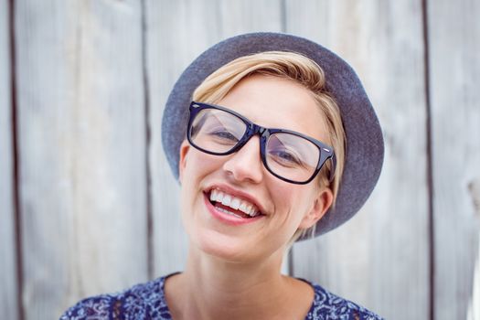 Pretty blonde woman wearing hipster glasses on wooden background