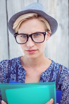 Pretty blonde woman holding folders on wooden background