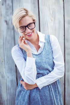Pretty blonde woman wearing hipster glasses on wooden background