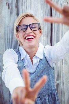 Pretty blonde woman wearing hipster glasses on wooden background