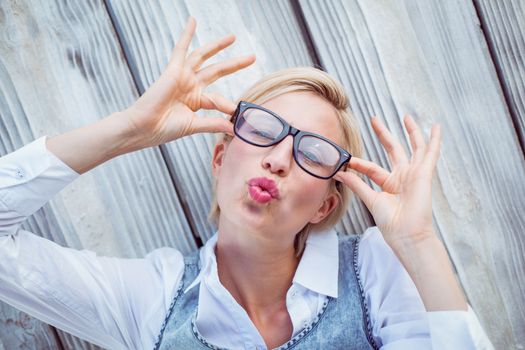 Pretty blonde woman having fun on wooden background