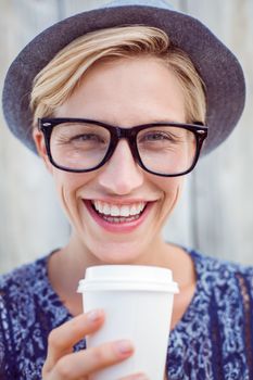 Pretty blonde woman holding goblet on wooden background