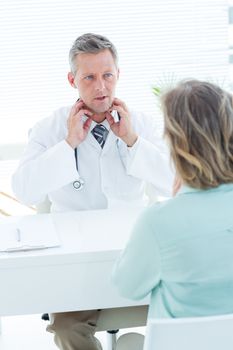 Doctor having conversation with his patient in medical office