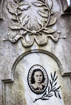 Portrait of the young woman on the old gravestone.