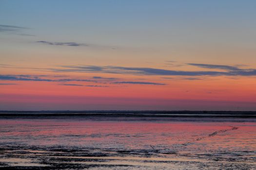 sun going down over mudflat at the german north sea coast