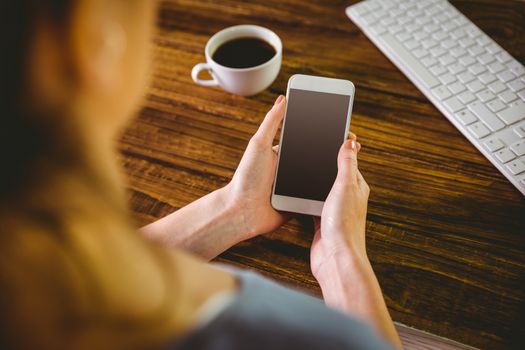 Woman using her smartphone on wooden table