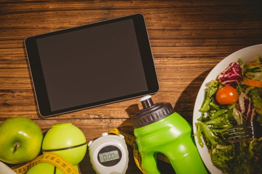 Tablet with indicators of healthy lifestyle on wooden table