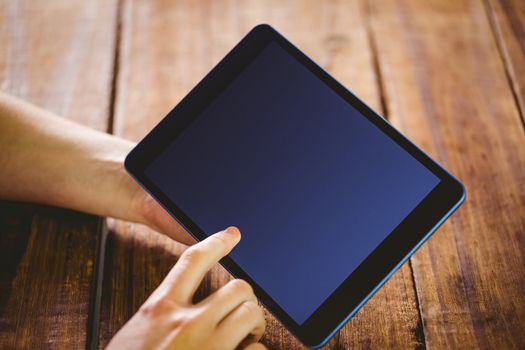 Woman using her tablet pc on wooden table