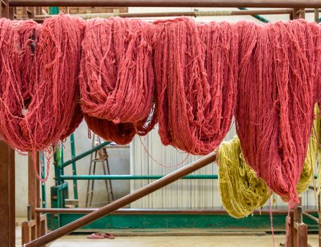 Red wool hanging in a carpet factory