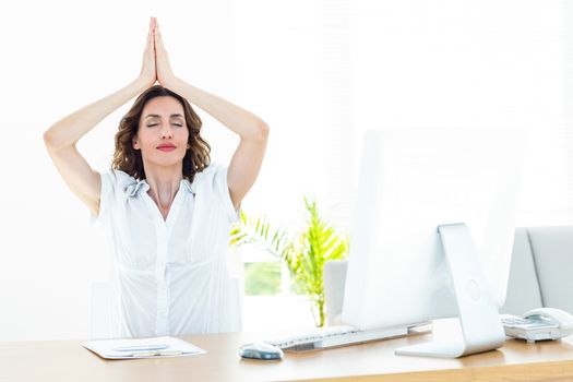 Relaxed businesswoman doing yoga on white background