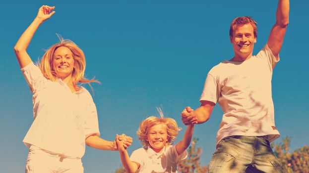 Beautiful family playing in the garden against a blue sky background
