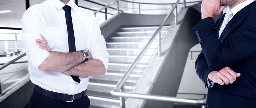 Smiling businessman with arms crossed against empty stair way 