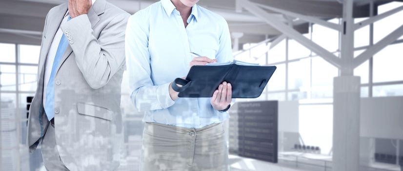 Businesswoman writing in her diary  against airport terminal