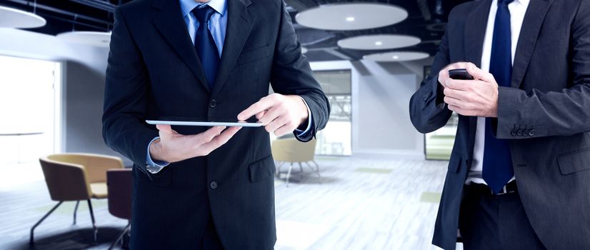 Focused businessman texting on his mobile phone against college