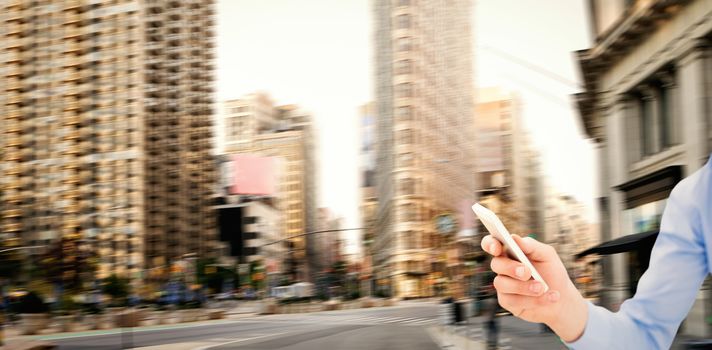 Man using smartphone against new york street