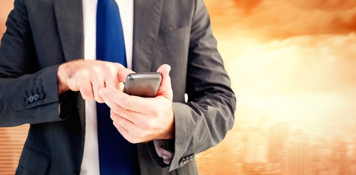 Businessman sending a text message against sun shining over city