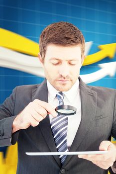 Businessman looking at tablet with magnifying glass against digital arrows with a graph