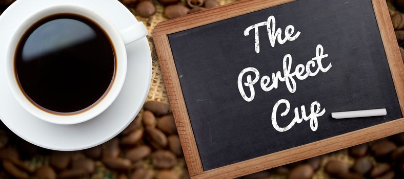 White cup of coffee against chalkboard with piece of chalk