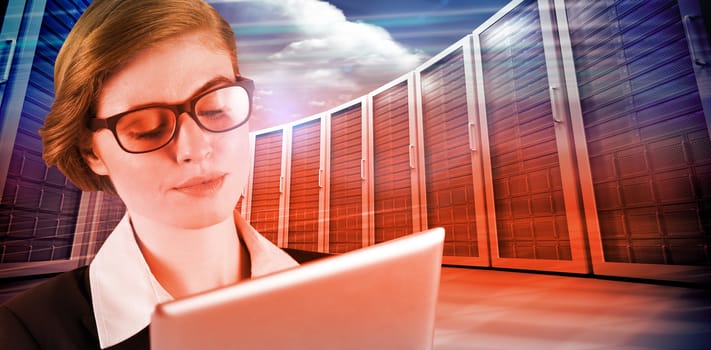 Redhead businesswoman using her tablet pc against composite image of server towers