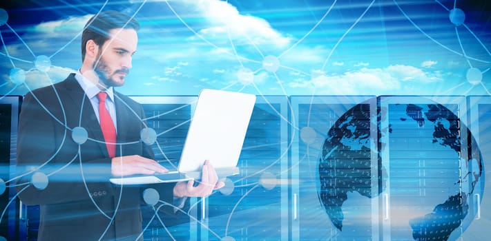 Focused businessman using his laptop against composite image of server towers