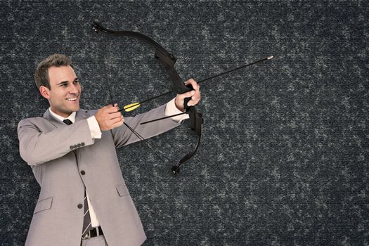 Businessman shooting arrow against black background