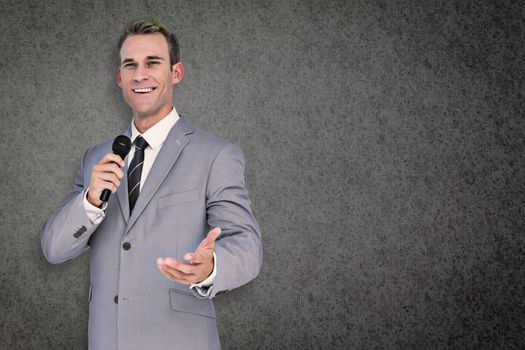 Businessman giving speech against grey background