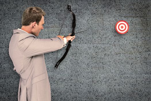 Businessman shooting target against grey background