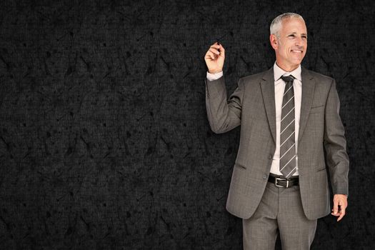 Businessman holding marker against grey background