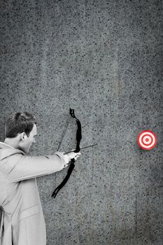 Businessman shooting target against grey background