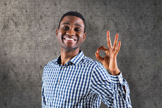 Happy businessman making ok sign against grey background