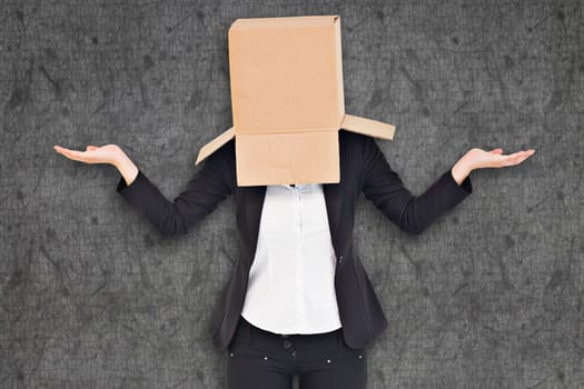 Businesswoman with box over head against grey background