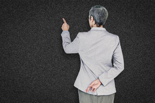 Businesswoman pointing against black background