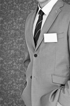 Businessman with badge against grey background