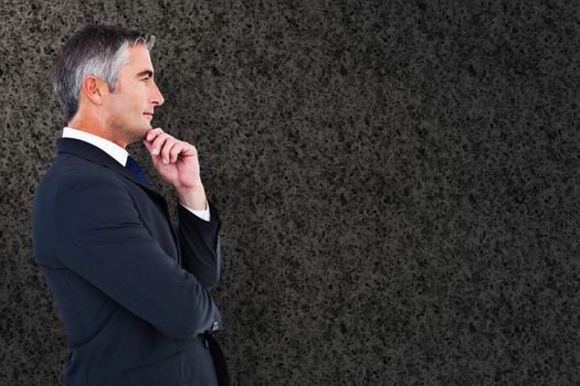 Elegant businessman in suit posing  against grey background