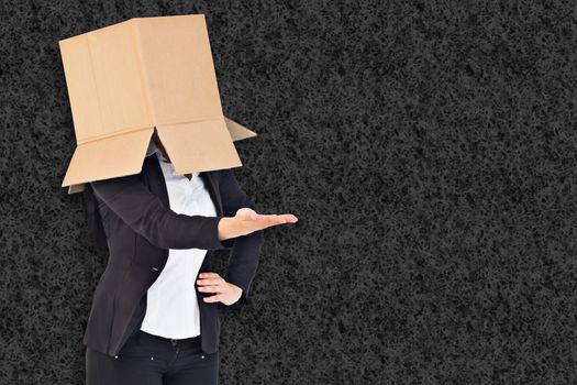 Businesswoman presenting with box over head against grey background