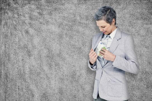 Businesswoman taking bribe against grey background