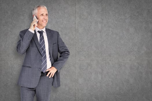 Businessman on the phone against grey background