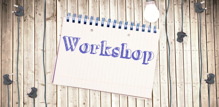 The word workshop against notepad on wooden surface