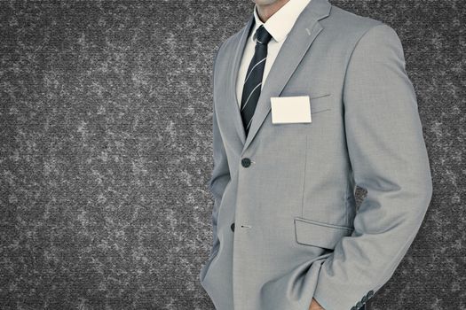 Businessman with badge against grey background