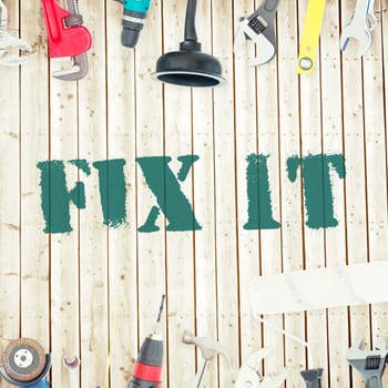 The word fix it against tools on wooden background