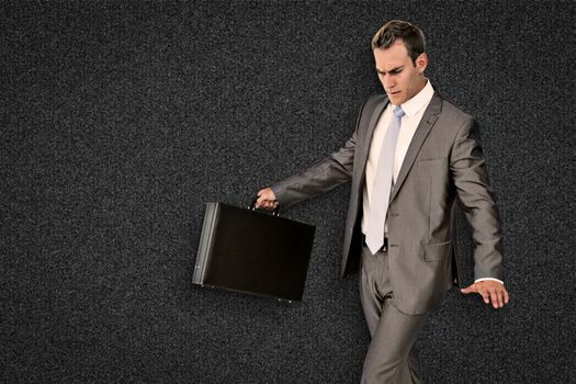 Businessman walking with his briefcase against black background