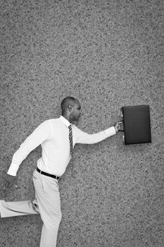 Businessman running with briefcase against grey background