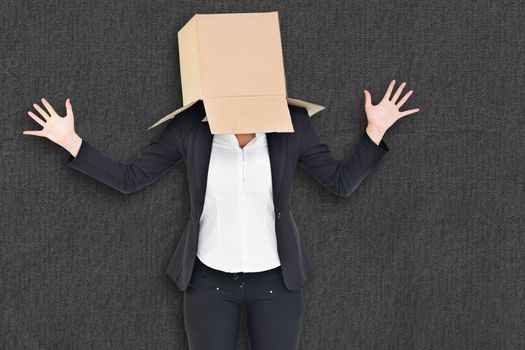 Businesswoman with box over head against grey background
