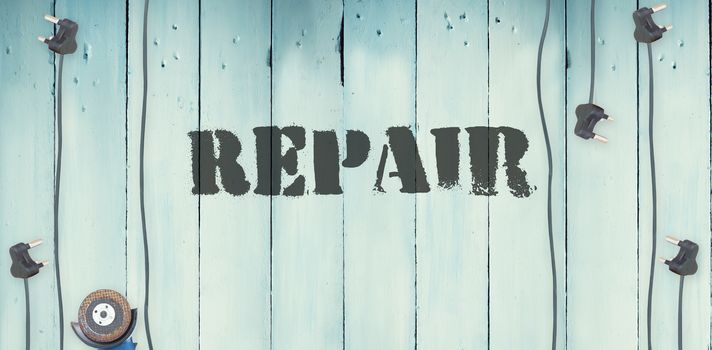 The word repair against plugs on wooden background