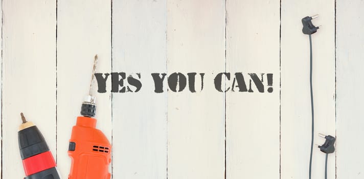 The word yes you can! against diy tools on wooden background