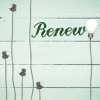 The word renew against light bulbs on wooden background