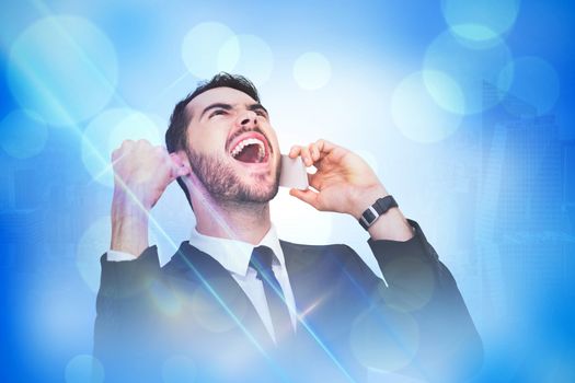 Cheering businessman in suit on the phone against blue abstract light spot design