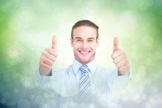 Positive businessman smiling with thumbs up against green abstract light spot design