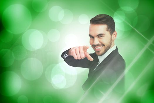 Happy businessman pointing his finger against green abstract light spot design